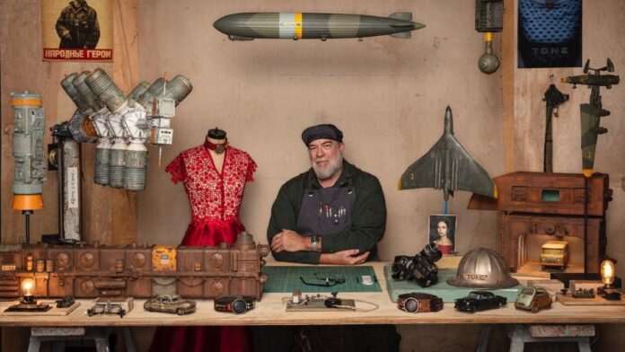 Dan Winters sitting in his studio by folding his hands