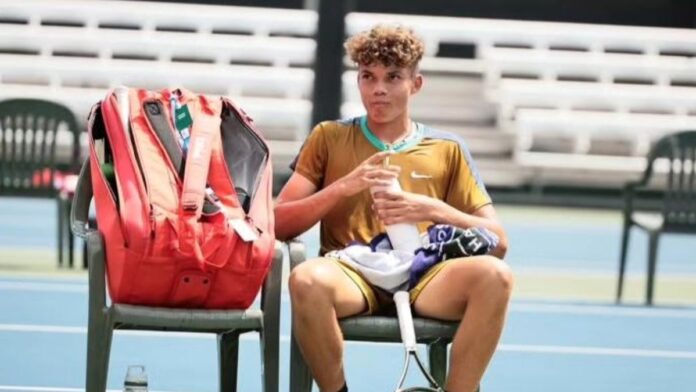 Darwin Blanch sitting with his tennis bat