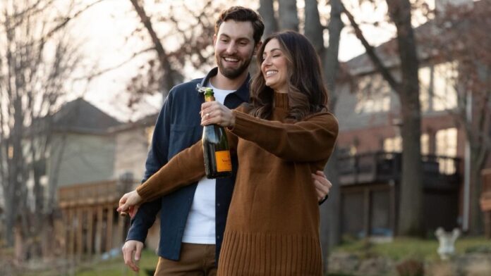 Lauren Jbara and Daniel Lockhart with a bottle of champagne