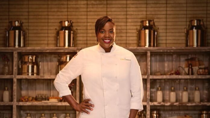 Michelle Wallace in chef attire standing in the kitchen.